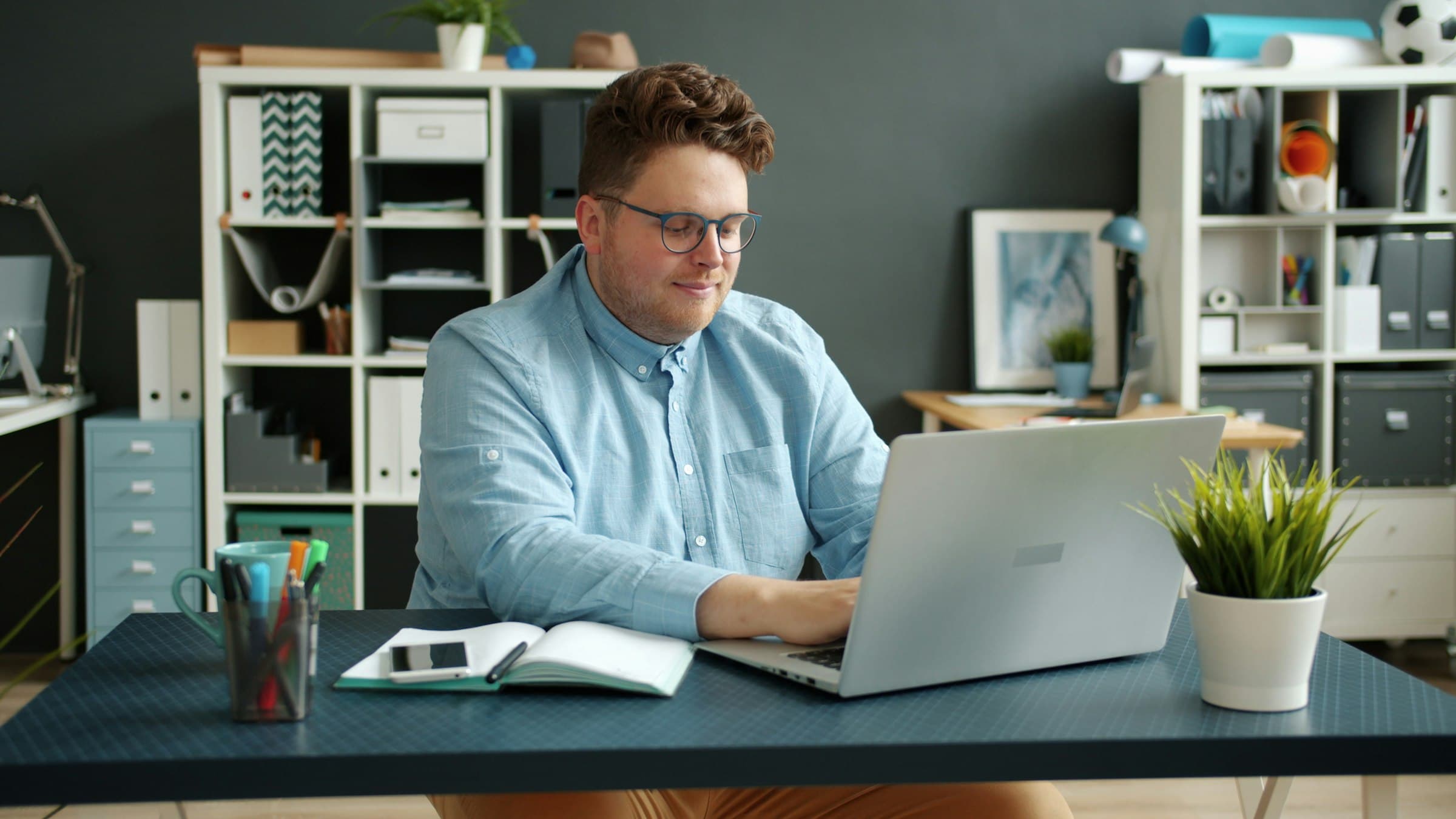 A buyer at his desk, working through supplier quotes on a laptop